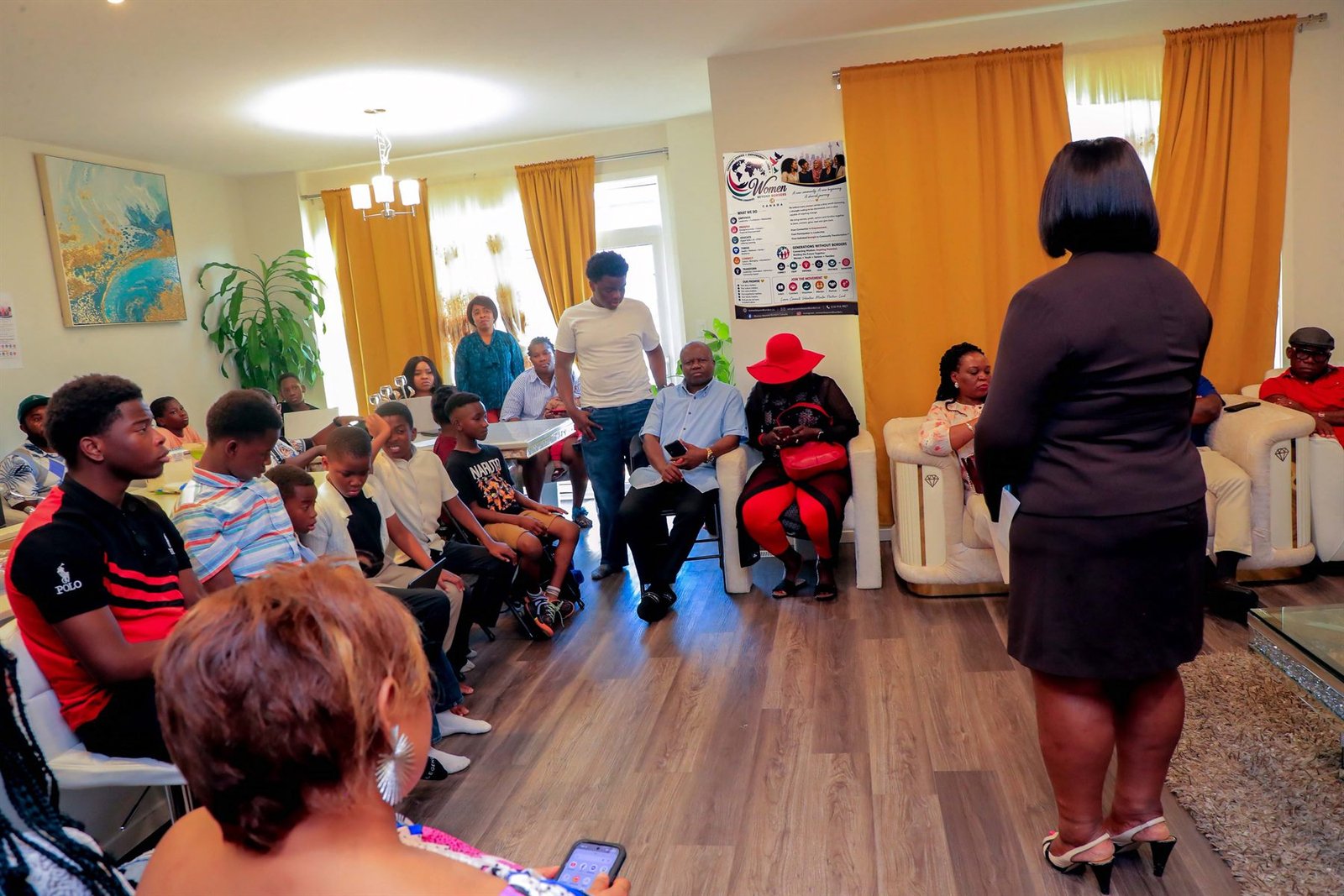 A Women Beyond Borders Canada facilitator speaking to a seated community group